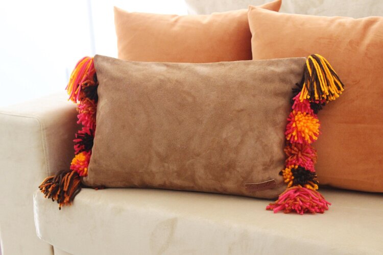 Burga - leather cushion with wool pom poms
